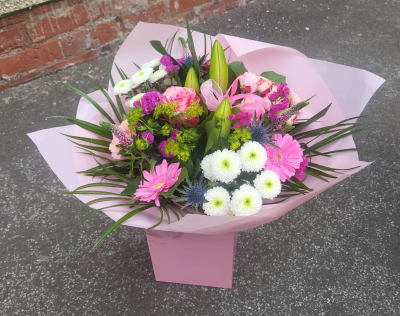 Blushing Meadow - A stunning collection of pink and green seasonal flowers in toning packaging. This bouquet is designed to impress and uplift any space.